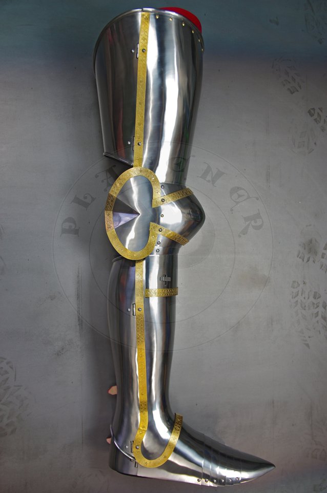 English style leg harness with fully closed cuisses, full greaves with characteristic line around outside ankles. Demi-greaves connected with greaves on rotary pin. Made of medium carbon steel of various thickness from 1 mm up to 1,5 mm. Heat hardened and tempered up to 42 HRC. Brass bands decoration motive based on example visible on Henry V tournament helm. Hand made steel buckles in set./Osony ng w stylu angielskim z w peni zamknitymi nabiodrkami, nagolennicami z charakterystyczn lini wok zewntrznej kostki. Demi-greave poczony z nagolennicami poprzez obrotowy pin. Wykonane ze stali redniowglowej rnej gruboci od 1 mm do 1,5 mm. Hartowane i odpuszczane do 42 HRC. Mosine listwy dekoracyjne z motywem wzorowanym na hemie turniejowym Henryka V. W zestawie rcznie robione sprzczki stalowe.